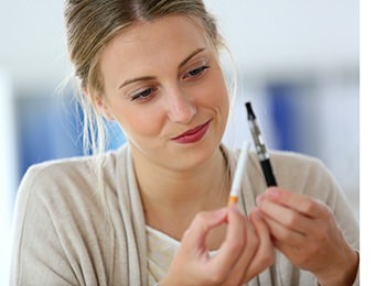 Young Blonde Girl deciding between Smoking and Vaping Marijuana