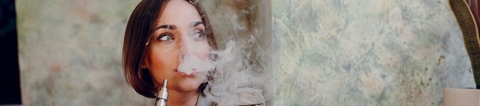 Young female is smoking a marijuana vape pen