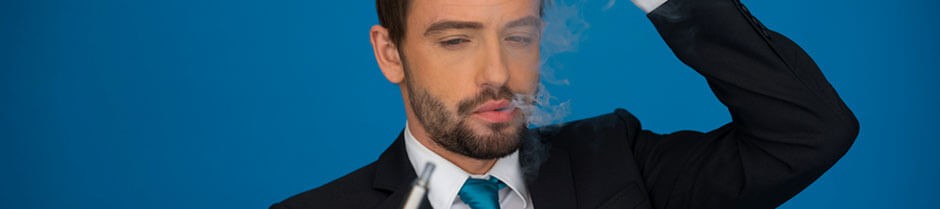 a confused young man is looking at a vape pen with vapor all around